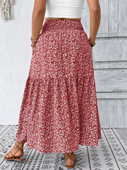Tiered maxi skirt in red with a white floral print, featuring a smocked waist and airy, casual style.