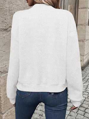 White geometric quilted bomber jacket with a mock neck and ribbed cuffs and hem.