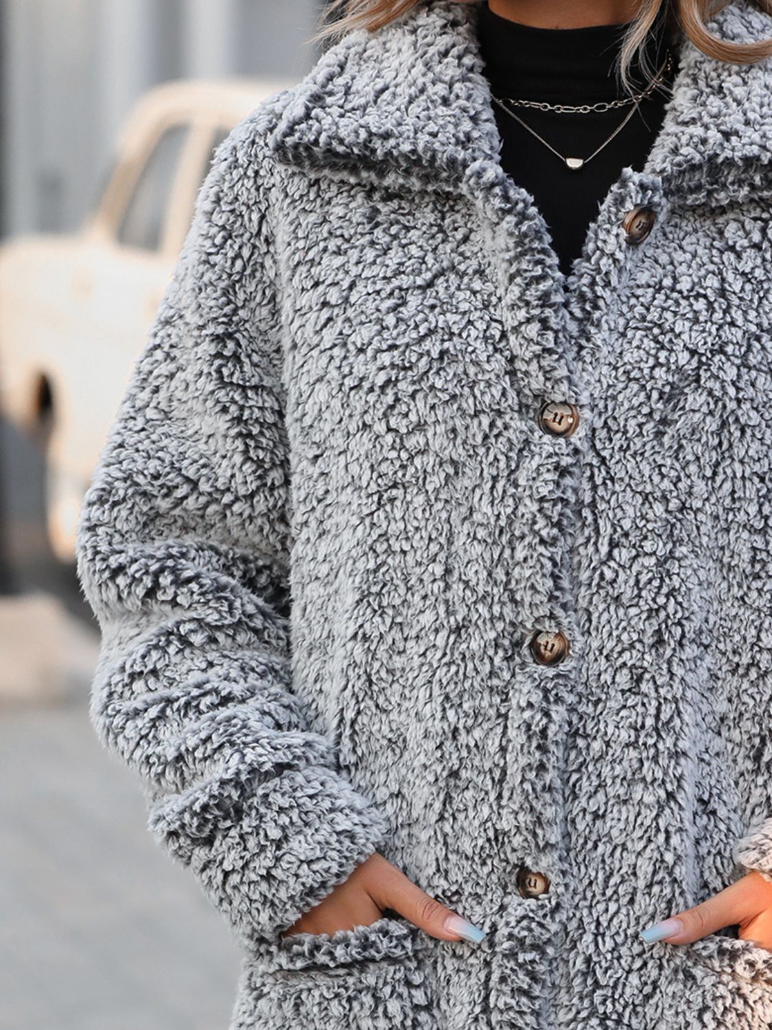 Teddy bear textured button-down coat in grey with brown buttons and pockets.