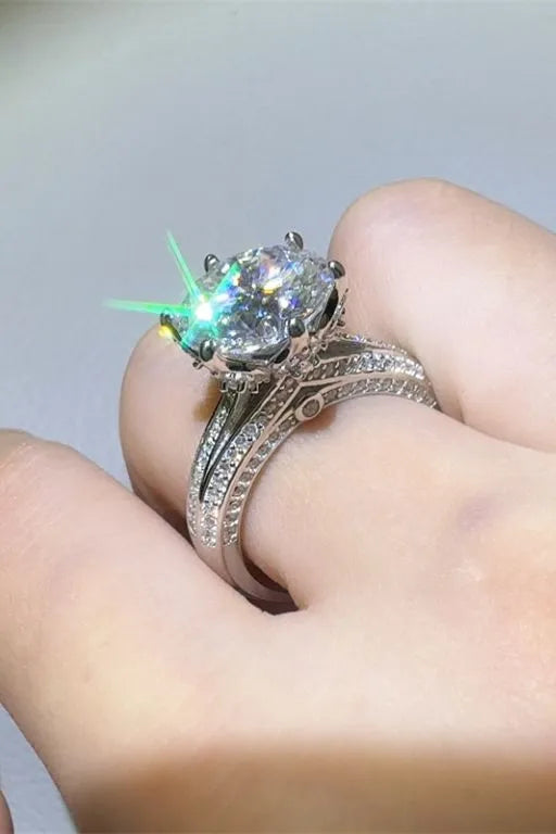 Silver moissanite ring with a large oval center stone and pavé band.