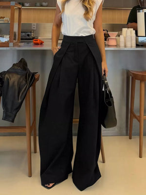 Black wide-leg pants with a high waist and pleats, styled with a white top.