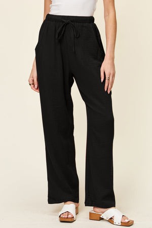 Black textured gauze relaxed drawstring trousers with pockets