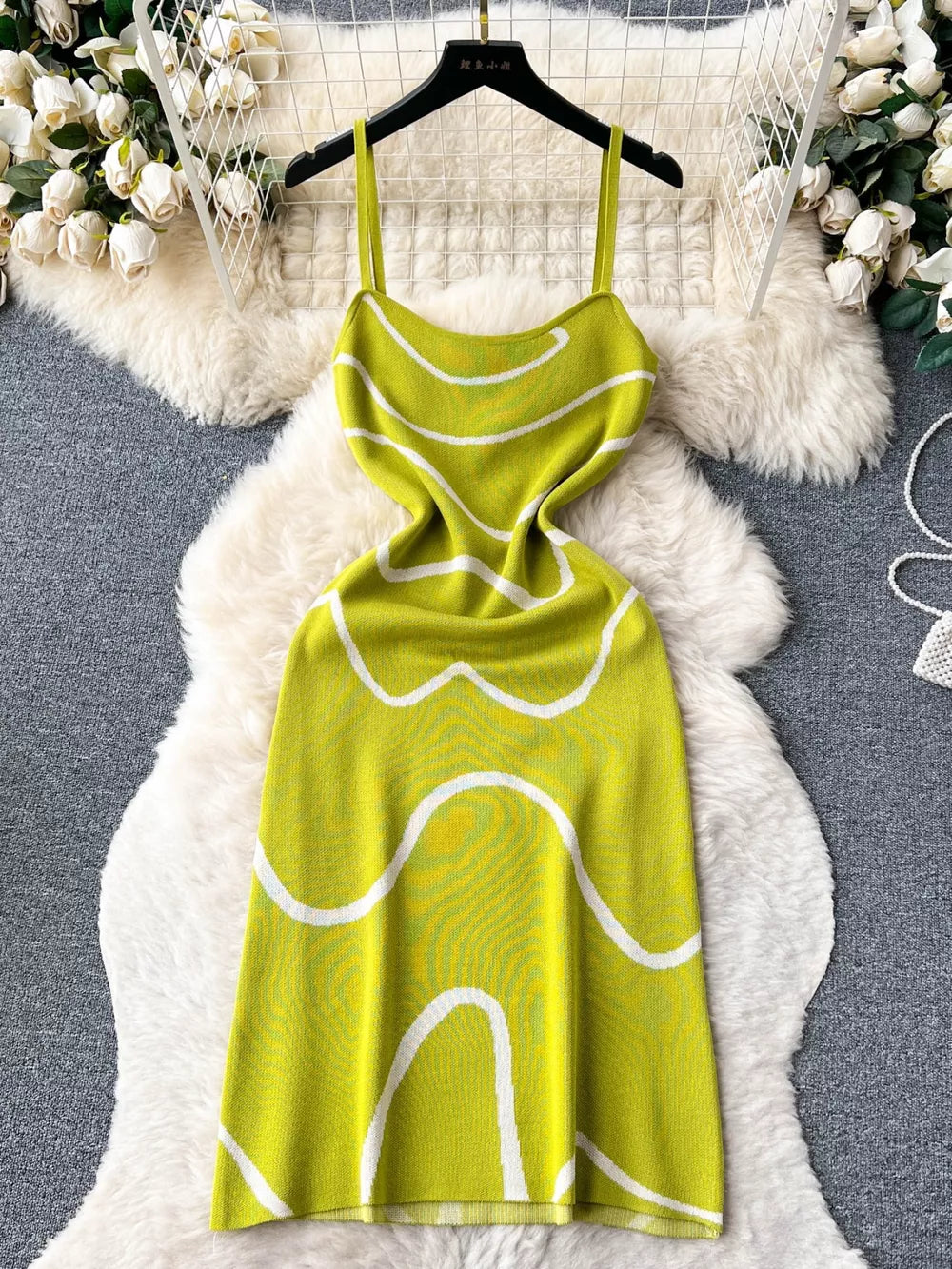 Green wavy knit midi dress with spaghetti straps and white abstract pattern.