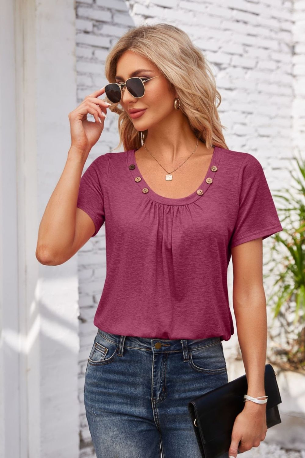 Button-trimmed gathered yoke top in deep purple with short sleeves and a scoop neckline.