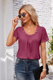 Button-trimmed gathered yoke top in deep purple with short sleeves and a scoop neckline.