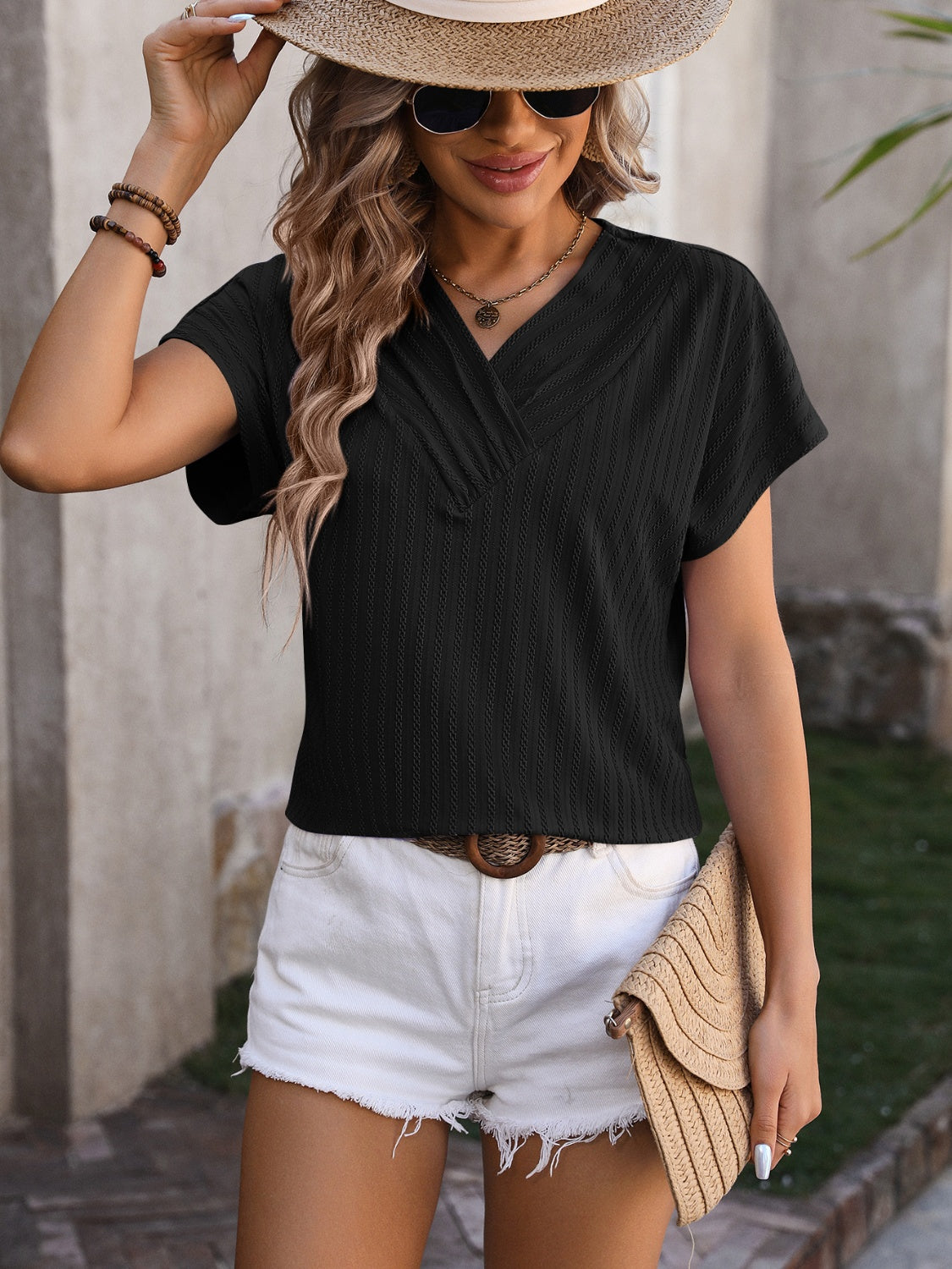 Black textured V-neck tee with short sleeves and a surplice neckline.
