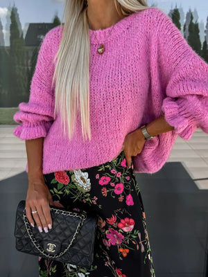 Fuchsia pink knit sweater with voluminous ruffled sleeves and crew neck.