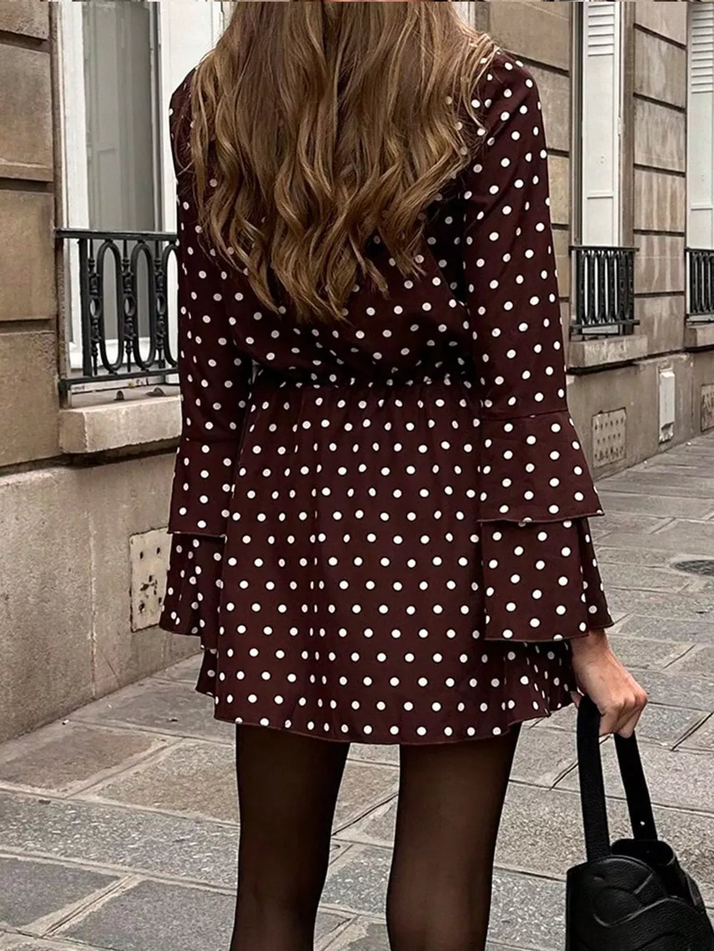 Brown polka dot mini dress with V-neck, tie detail, and tiered bell sleeves.