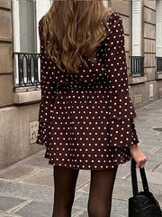 Brown polka dot mini dress with V-neck, tie detail, and tiered bell sleeves.