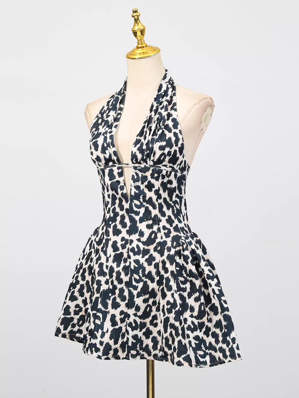 Leopard print halter neck mini dress with a deep V-neck and flared skirt.