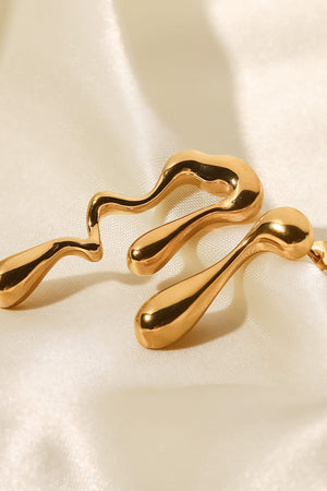 Gold asymmetrical drip earrings with a fluid, artistic design.