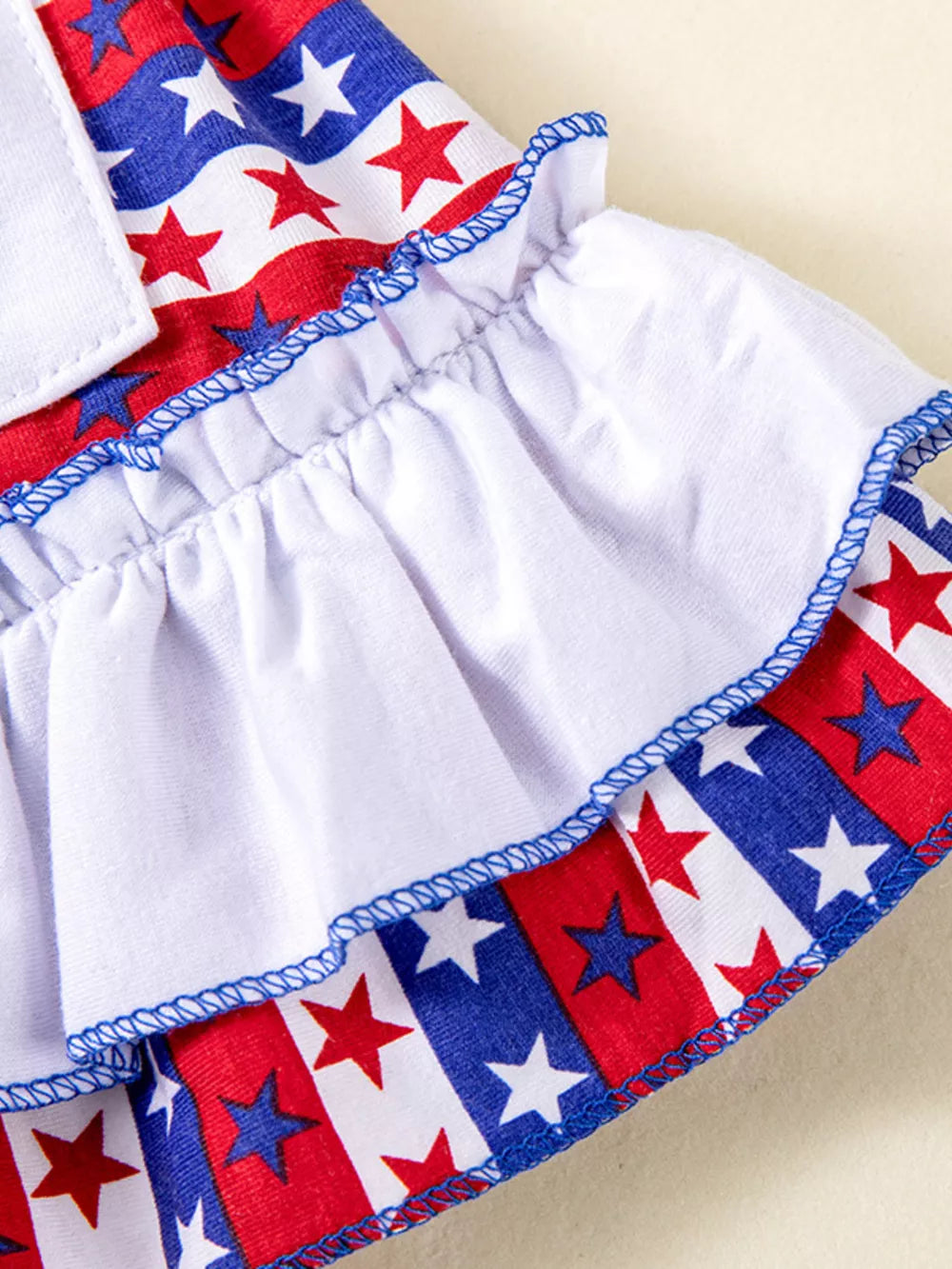 Baby dress with ruffled hem and star-spangled print, blue trim, cotton