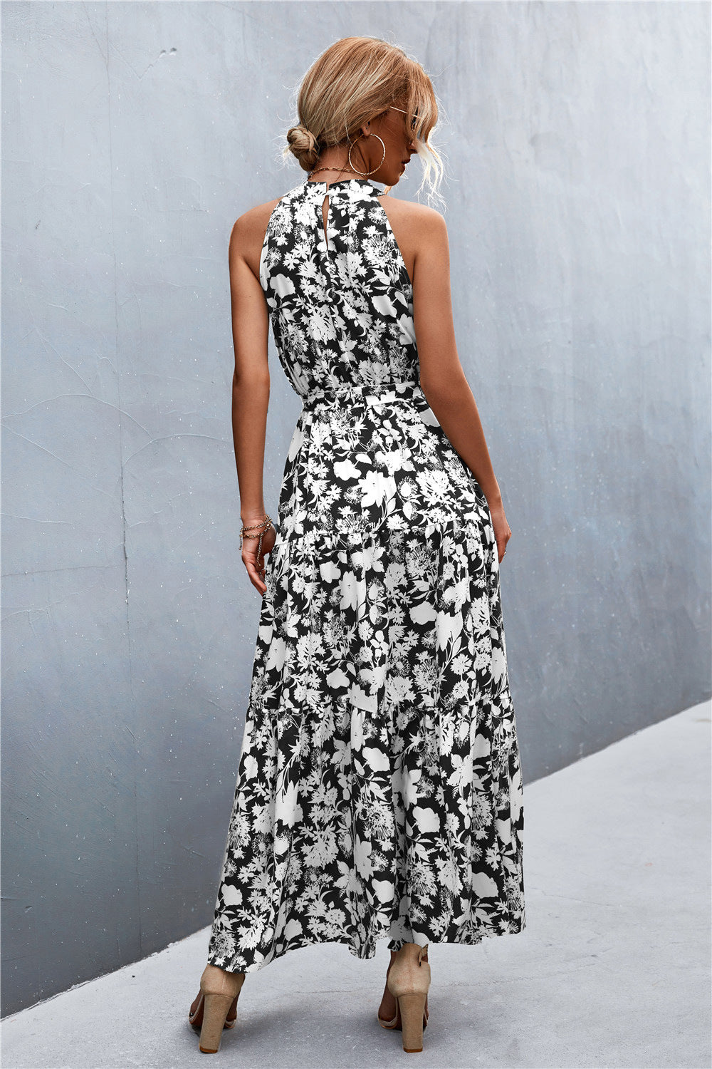 Black and white floral print maxi dress with halter neckline and tiered skirt.