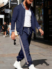 Navy track pants with white drawstring and side stripe detail, worn by a man.