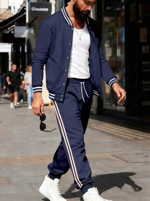 Navy track pants with white drawstring and side stripe detail, worn by a man.