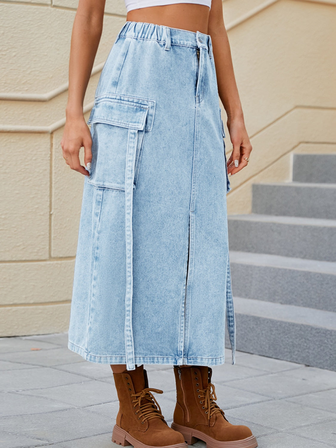 Light blue denim midi skirt with cargo pockets and front slit detail.