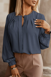 Misty Blue pleated yoke blouse with button detail and elastic cuffs.