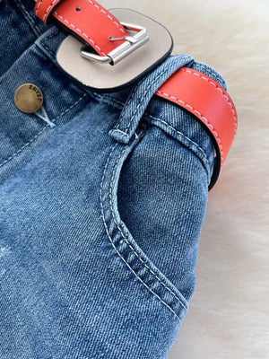 Denim midi skirt with red belt detail and button closure.