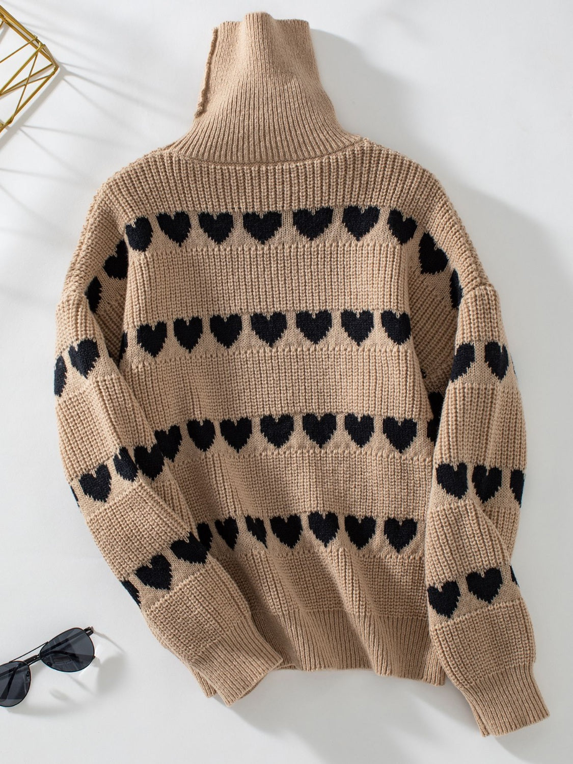 Taupe turtleneck sweater with black heart intarsia pattern and ribbed cuffs.