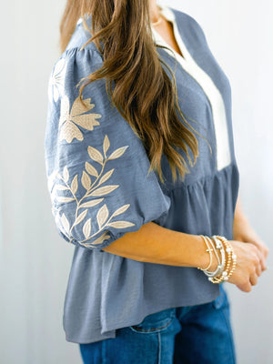 Blue peplum blouse with elbow sleeves and embroidered floral detail