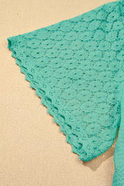 Turquoise lace-trimmed waffle knit shirt with short sleeves and a scalloped hem.