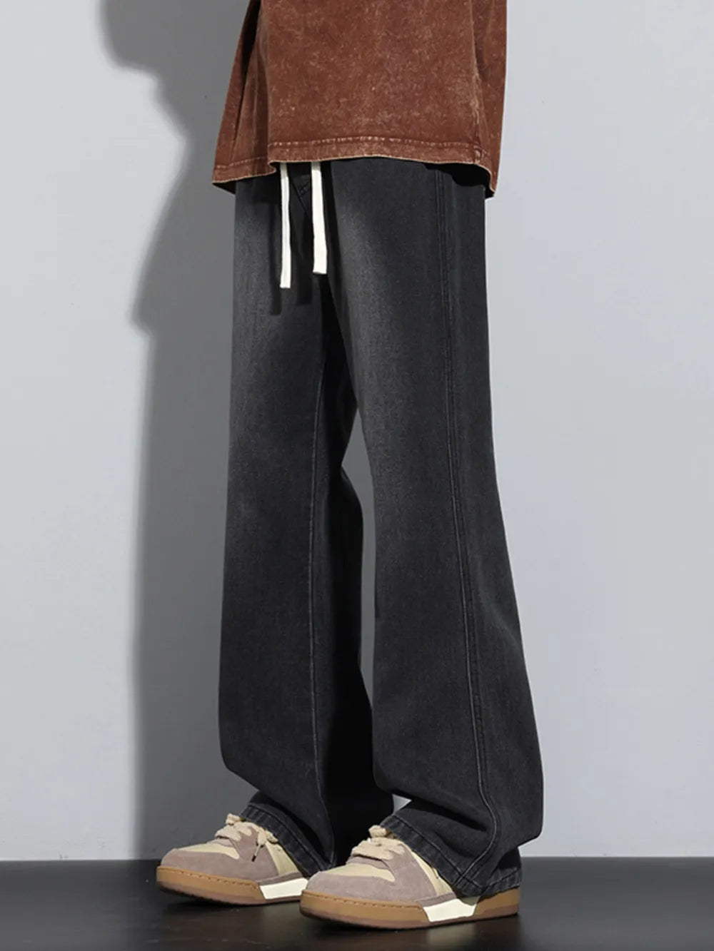 Men's black vintage wash drawstring jeans with a relaxed fit.