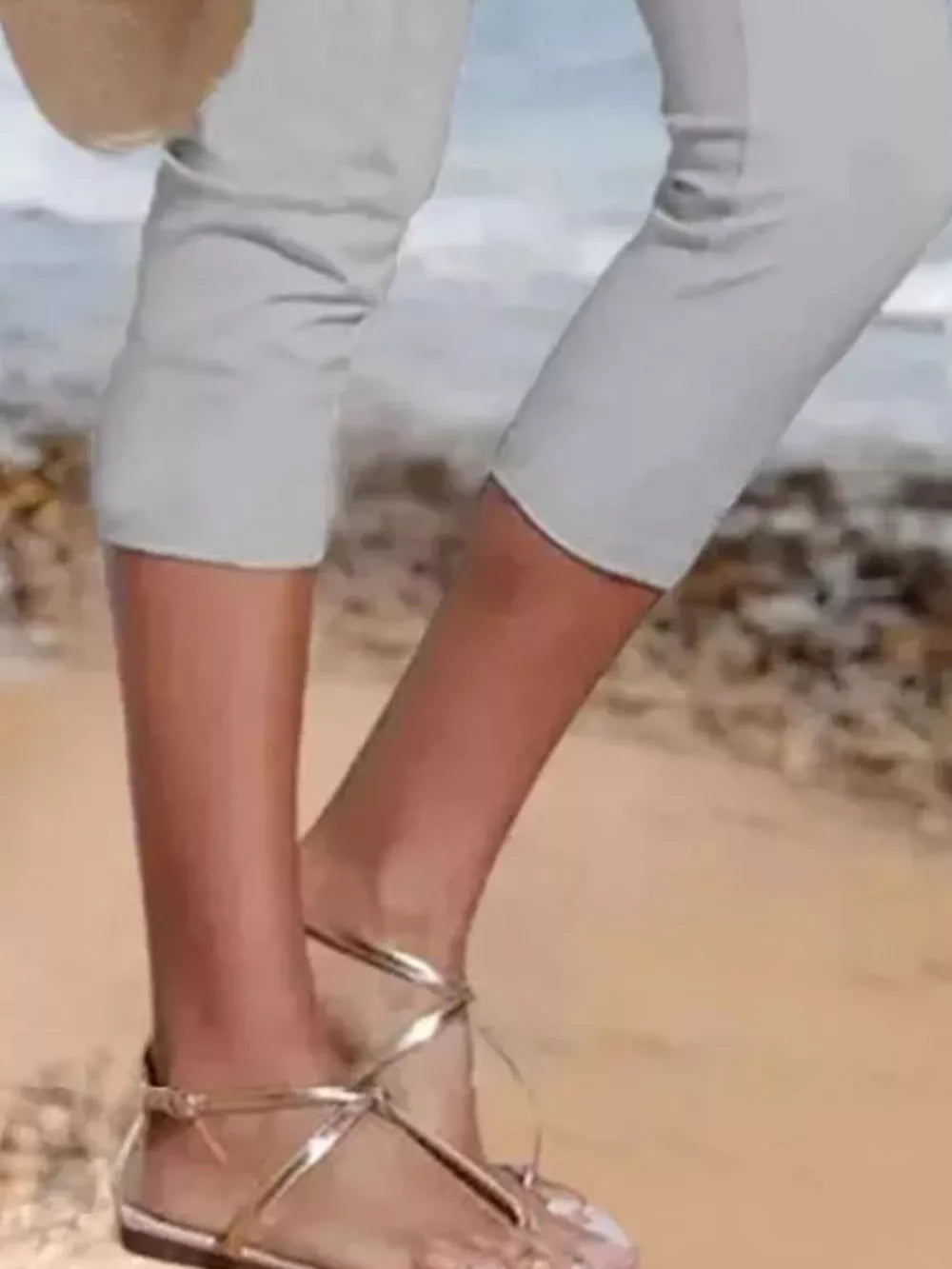 Light gray cropped leggings shown on a beach, hitting mid-calf.