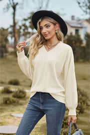 Ivory textured cable knit v-neck sweater with balloon sleeves.
