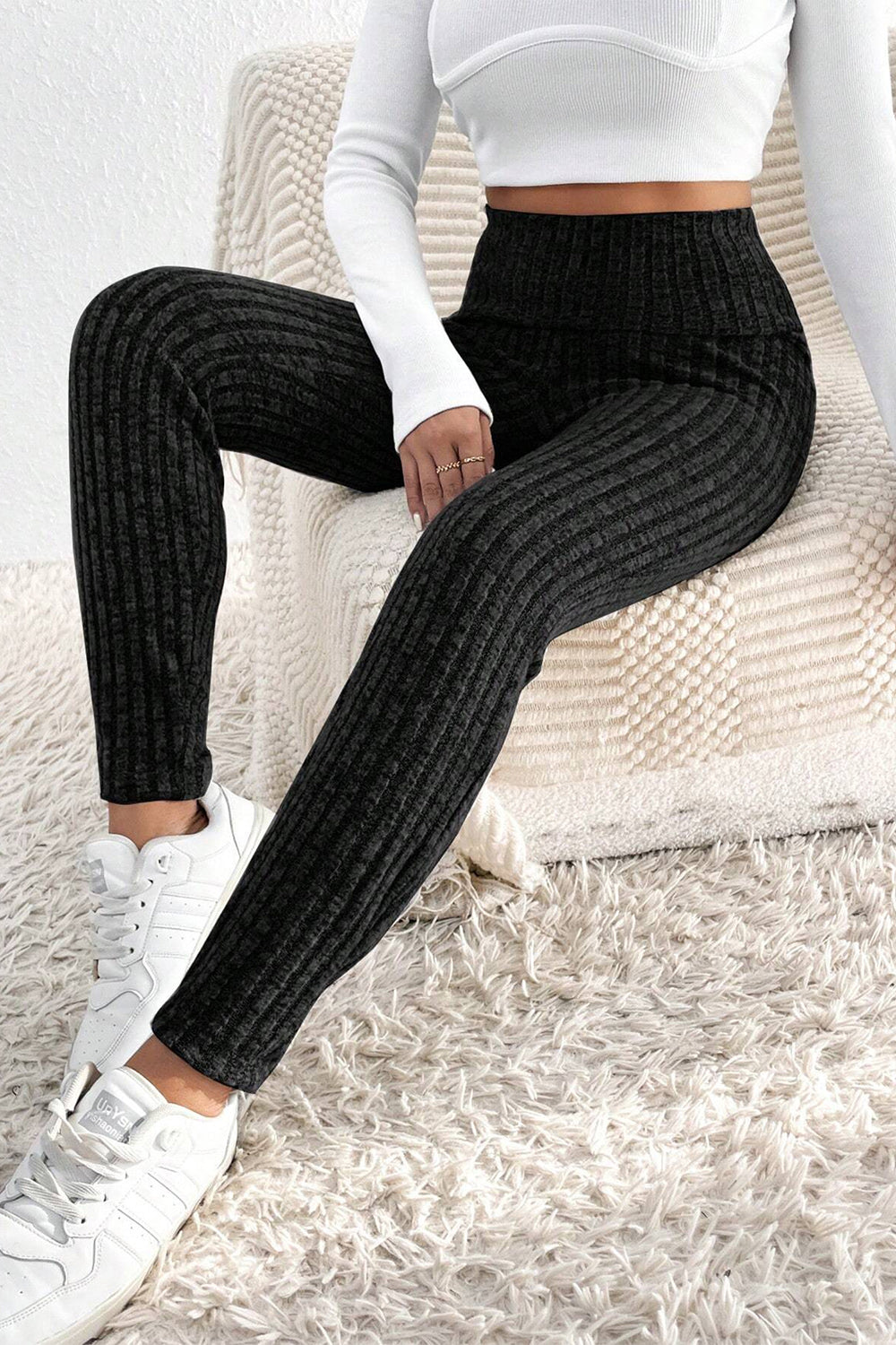 Black textured knit leggings with a high waist and ribbed detail.