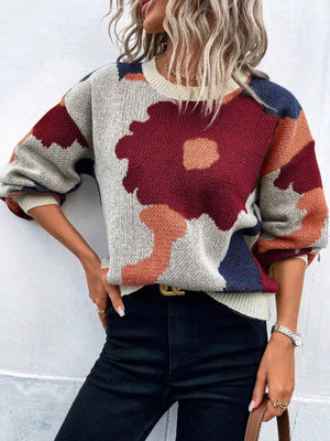 Abstract floral knit sweater with round neck in burgundy, orange, blue, and cream.