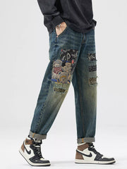 Men's distressed blue cotton jeans with patchwork teddy bear and bandana prints.