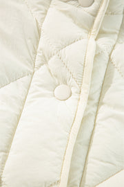 Ivory quilted vest with diamond stitching and a snap closure detail.