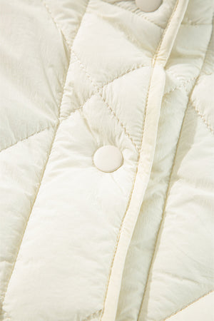 Ivory quilted vest with diamond stitching and a snap closure detail.