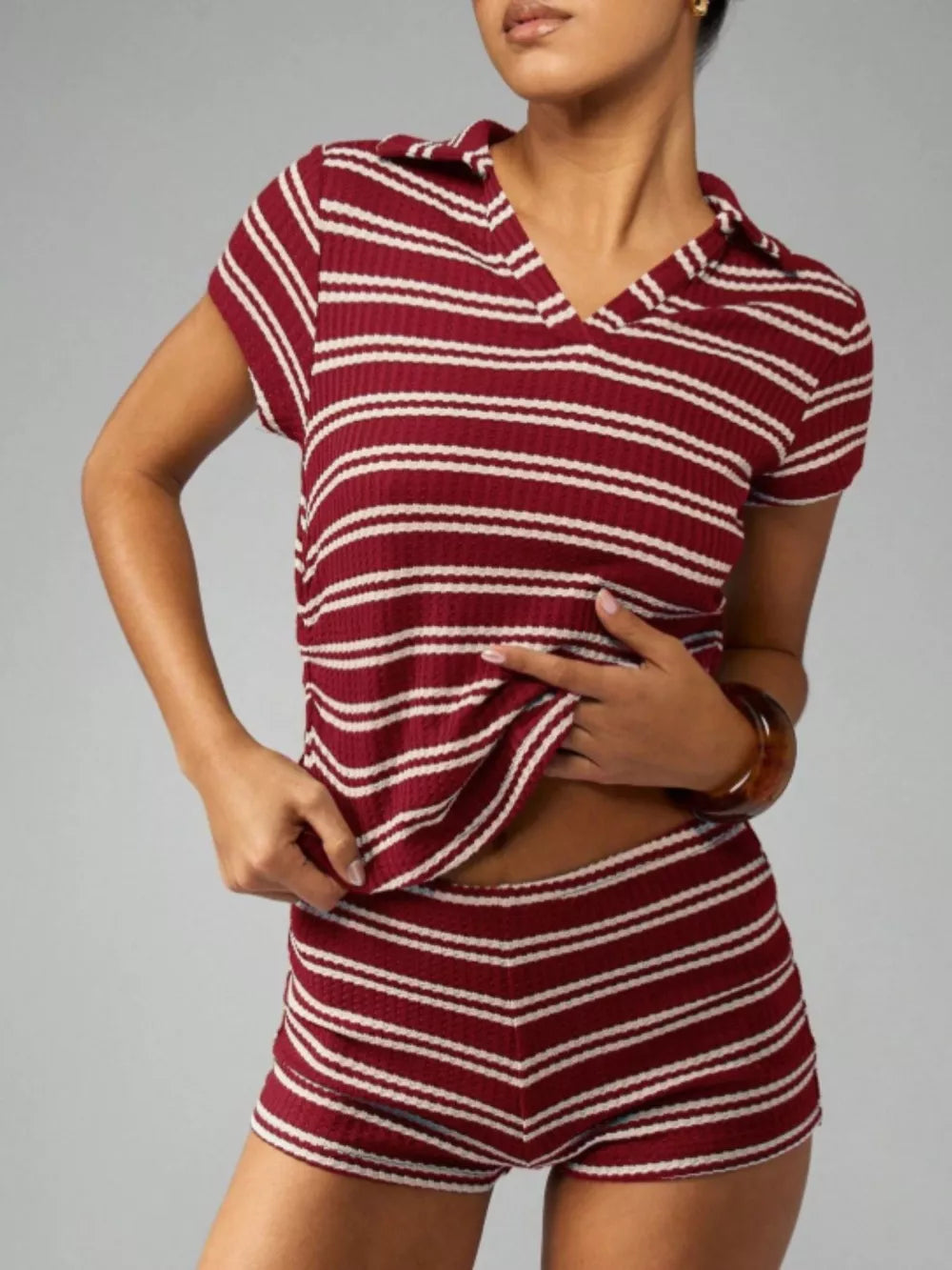 Burgundy striped knit two-piece set with collared short-sleeve top and chevron shorts.