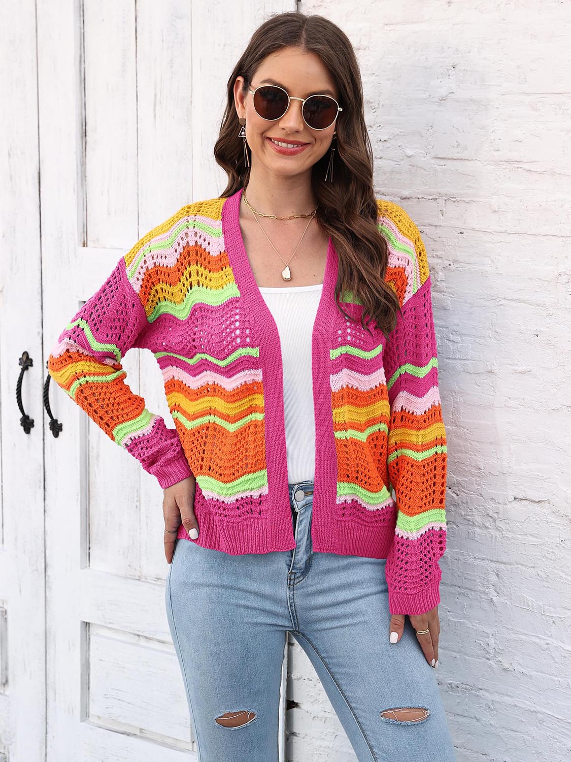 Crochet cardigan with rainbow wave pattern in pink, orange, yellow, and green acrylic.