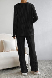 Black ribbed knit lounge set with long sleeves and flared pants.