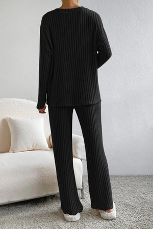 Black ribbed knit lounge set with long sleeves and flared pants.