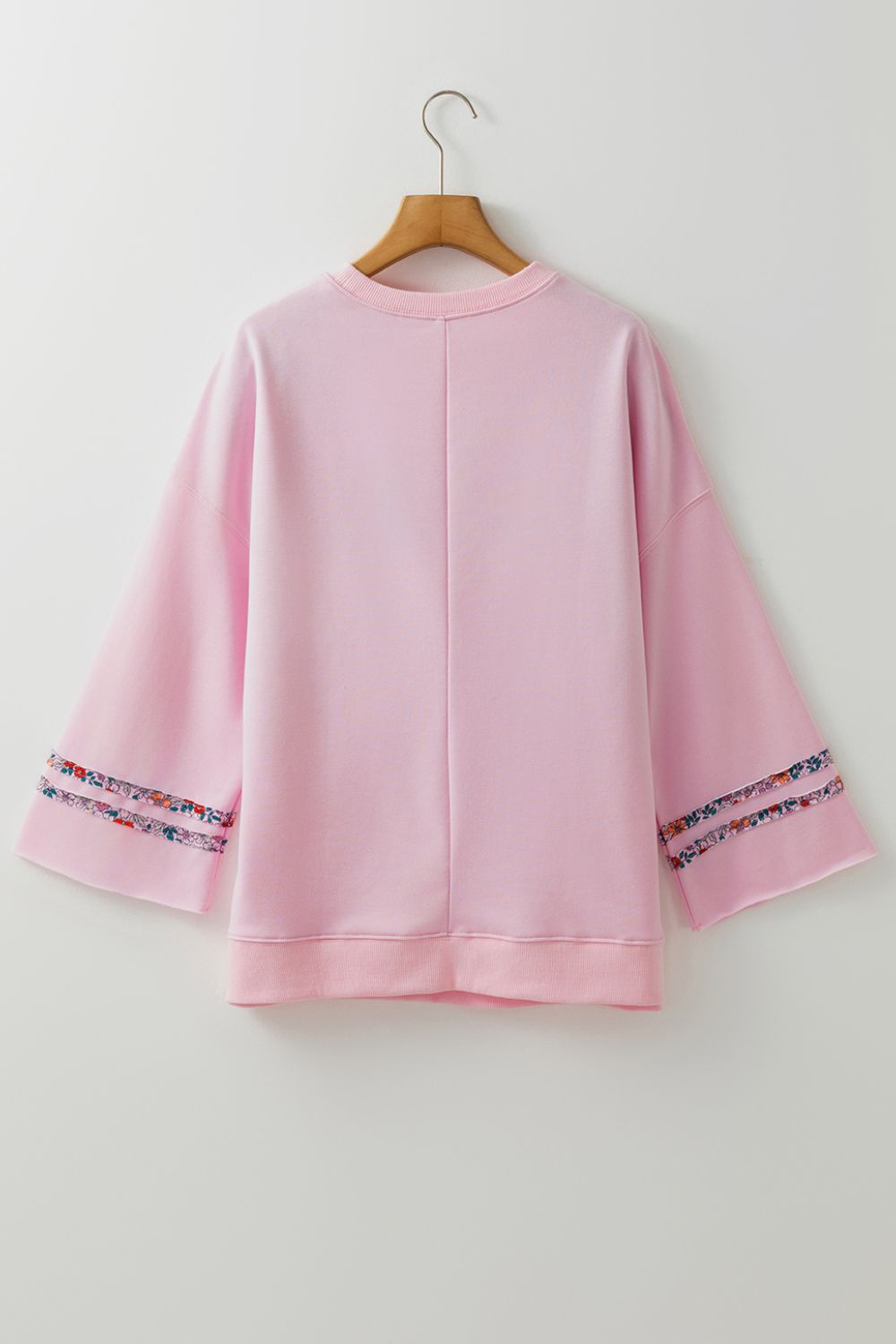 Dusty Pink sweatshirt with floral trim on bell sleeves.