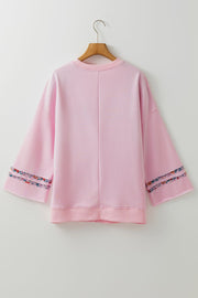 Dusty Pink sweatshirt with floral trim on bell sleeves.