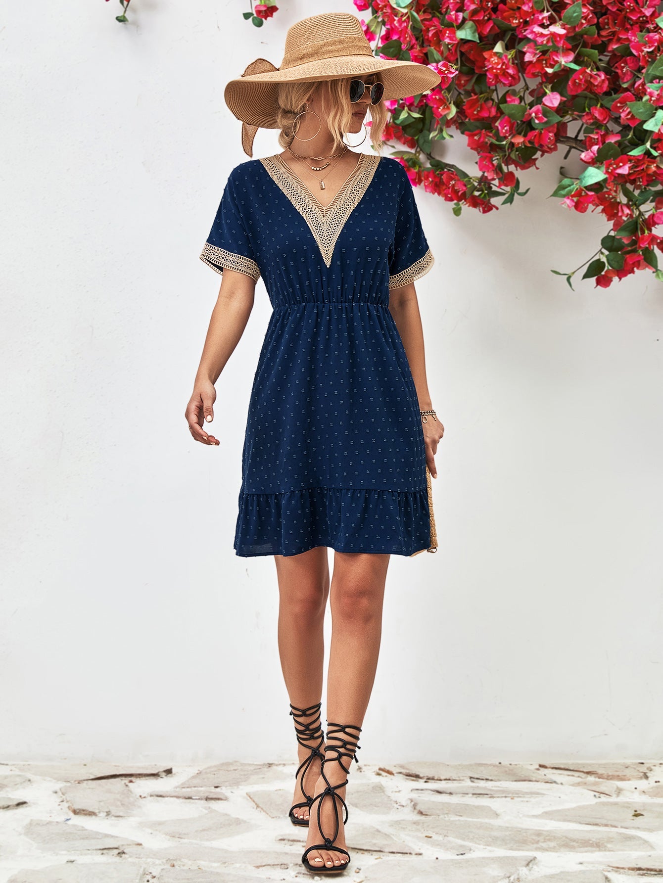 Dark blue Swiss dot dress with crochet trim V-neck, elastic waist, and ruffled hem.