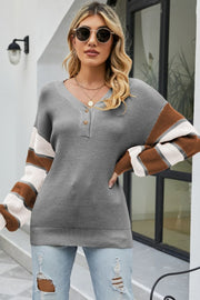 Waffle knit henley sweater in grey with striped sleeves and button neck detail.