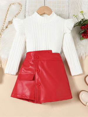 Baby red leather skirt with button details and white ribbed knit top with ruffled shoulders.