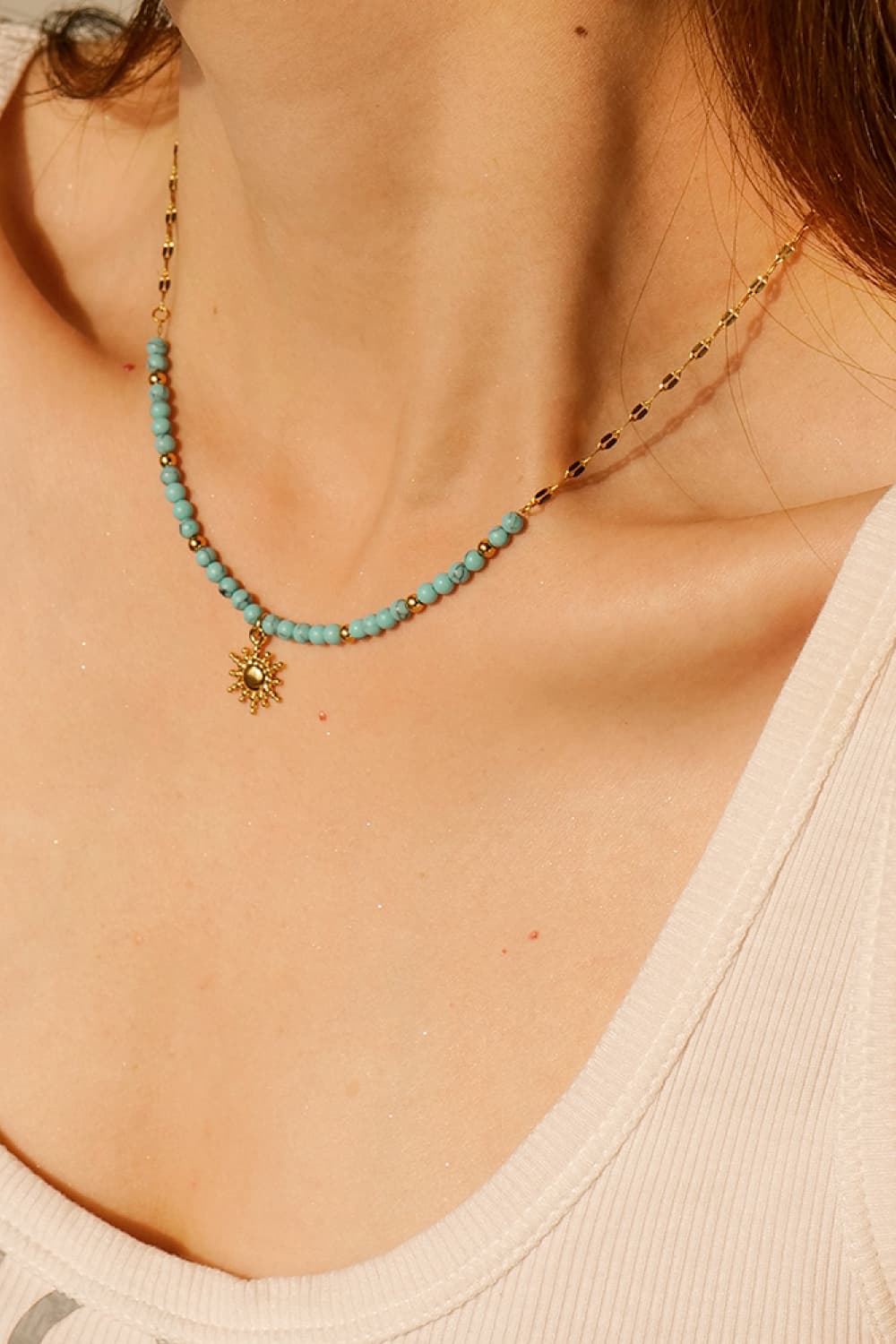 Gold celestial sunburst beaded necklace with turquoise beads and a delicate chain.