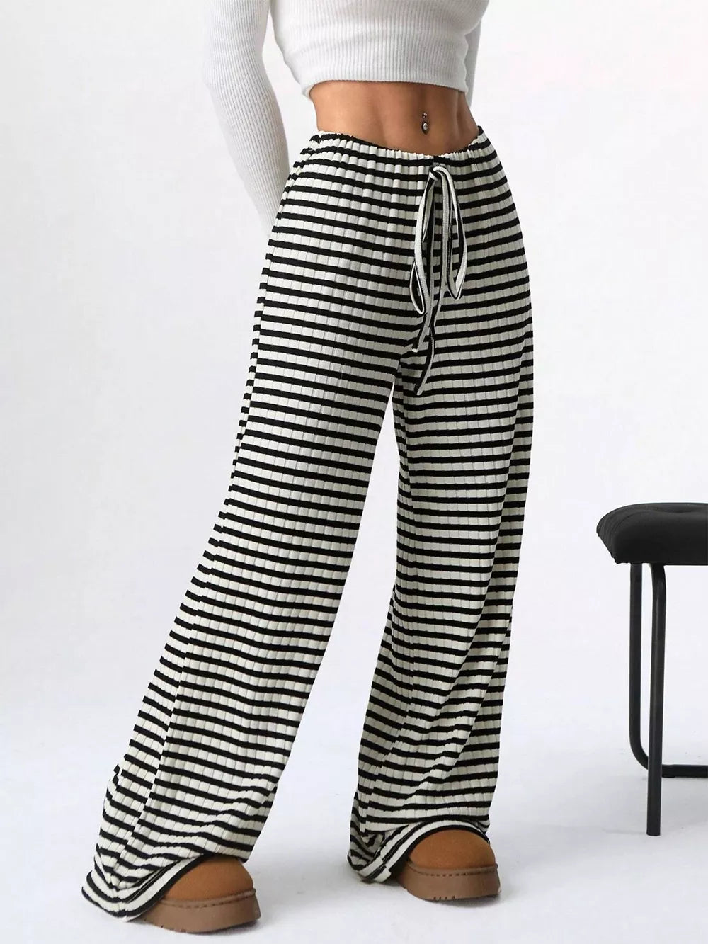 Striped ribbed wide-leg pants with drawstring waist and black and white pattern.