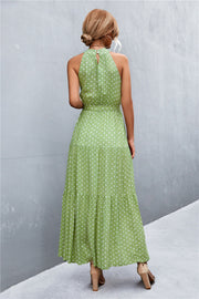 Maxi dress with halter neckline, polka dot print, tiered skirt, and belted waist in Gum Leaf green.