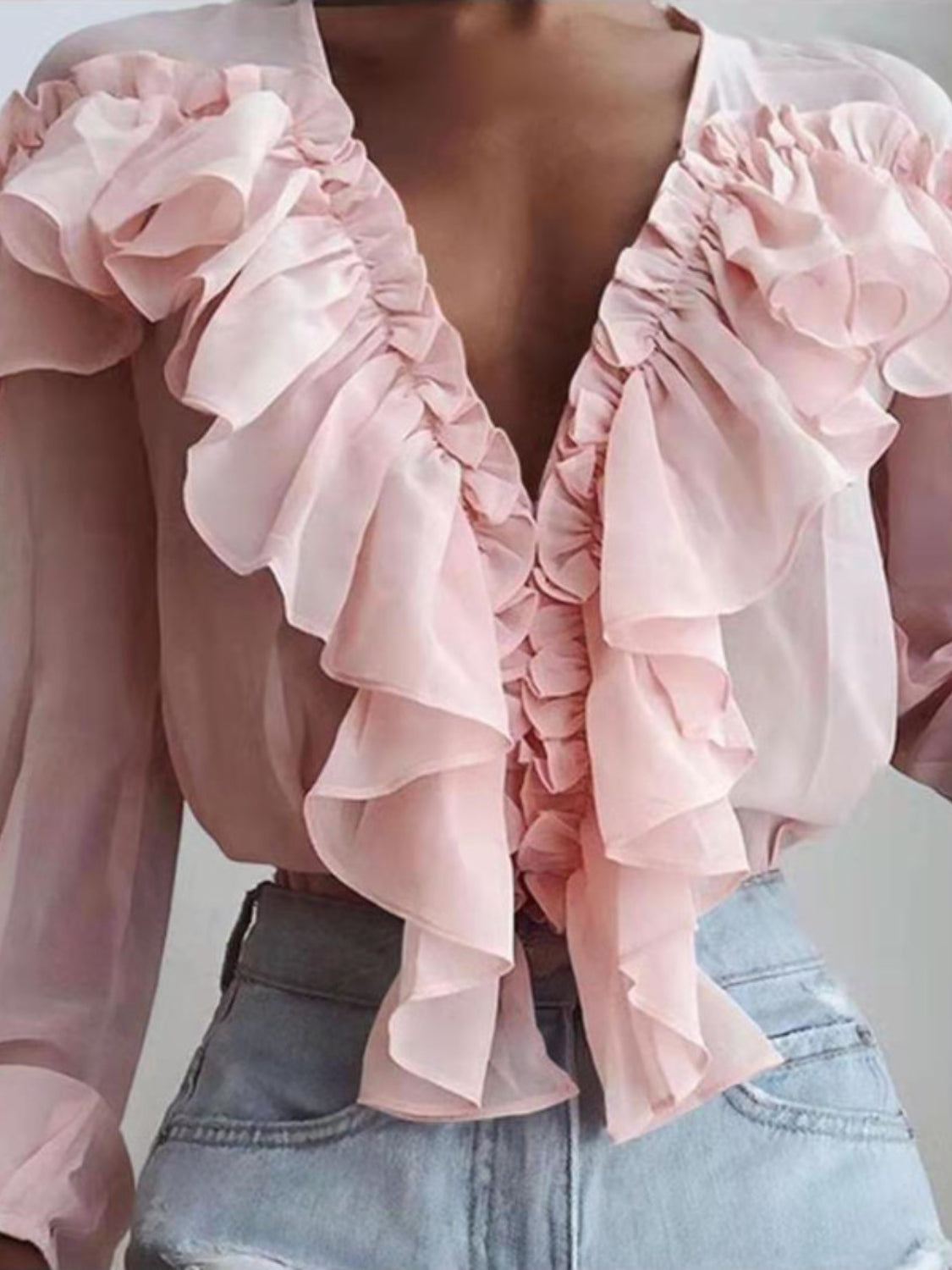 Pink chiffon ruffle plunge blouse with cascading ruffles and long sleeves.