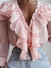 Pink chiffon ruffle plunge blouse with cascading ruffles and long sleeves.