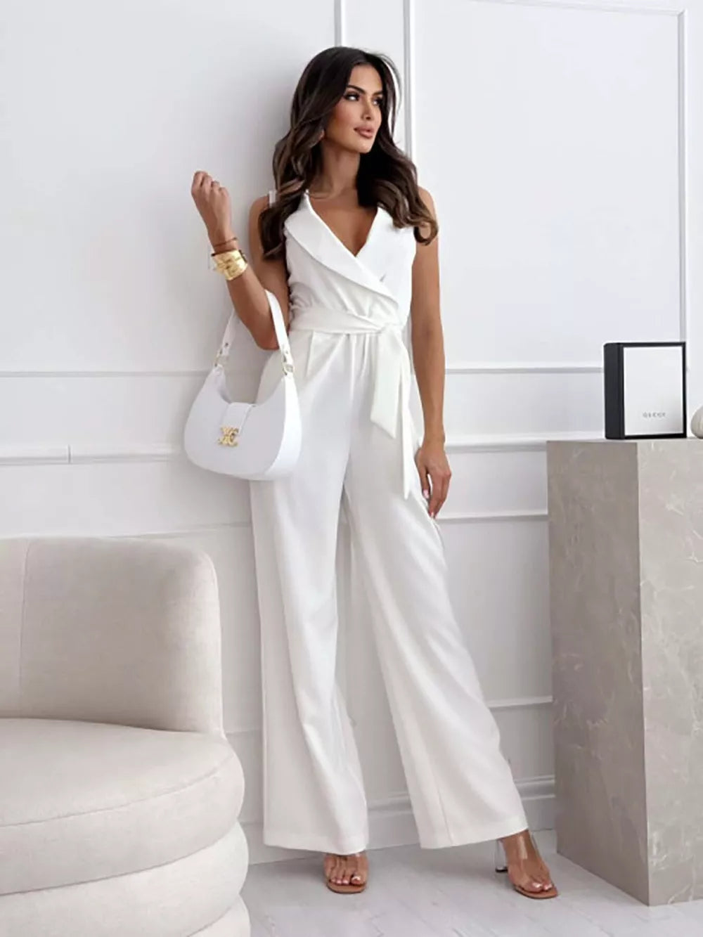 White wrap-front wide-leg romper with belted waist and V-neck.
