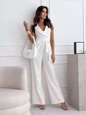 White wrap-front wide-leg romper with belted waist and V-neck.