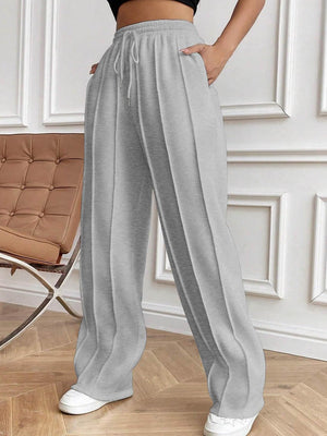 Light gray pleated palazzo trousers with drawstring waist and wide legs.